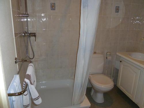 a bathroom with a tub and a toilet and a sink at Guest house Adonis in Bruges
