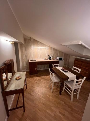 een kamer met een tafel en stoelen en een keuken bij B&B Poggio San Luca in Bologna