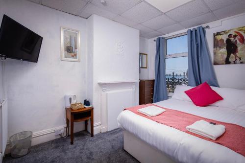 Ένα ή περισσότερα κρεβάτια σε δωμάτιο στο The Beachfront Hotel