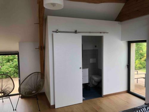 une chambre avec une porte blanche et deux chaises dans l'établissement Petite maison dans fosse troglodytes, à Chemellier