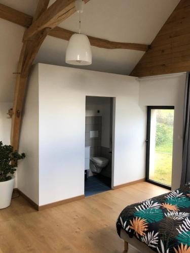 une grande chambre avec un lit et une salle de bain dans l'établissement Petite maison dans fosse troglodytes, à Chemellier