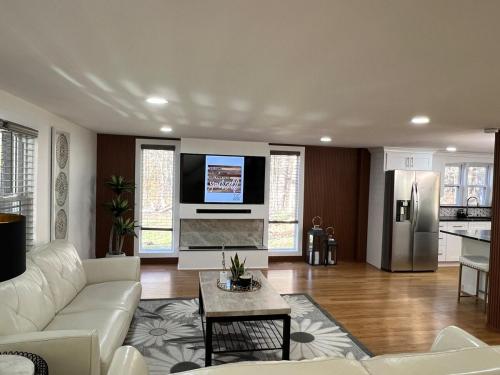 a living room with a white couch and a refrigerator at Catskills Escape Hot Tub Massage Chairs & Games in Round Top