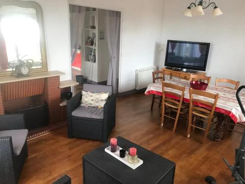 un salon avec une télévision et une salle à manger dans l'établissement Appartement confortable avec jardin à Objat, 120 m², à Objat