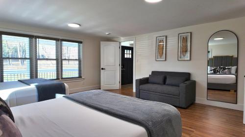 a bedroom with a bed and a chair and a mirror at Catskills Escape Hot Tub Massage Chairs & Games in Round Top