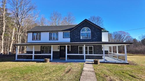 a home with a black and white house at Catskills Escape Hot Tub Massage Chairs & Games in Round Top