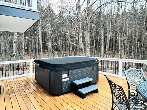 a hot tub on the deck of a house at Catskills Escape Hot Tub Massage Chairs & Games in Round Top
