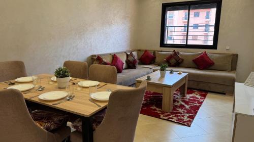 een woonkamer met een tafel en een bank bij Magnifique appartement Marrakech in Marrakesh
