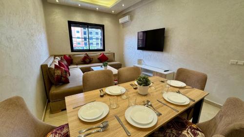 een eetkamer met een tafel, stoelen en een bank bij Magnifique appartement Marrakech in Marrakesh