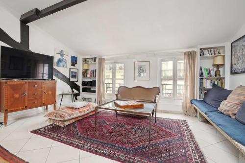 un salon avec un canapé et une télévision dans l'établissement Le Majestueux, à Paris