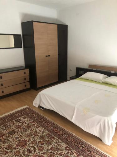 a bedroom with a bed with a dresser and a closet at Ema's apartments in Bihać