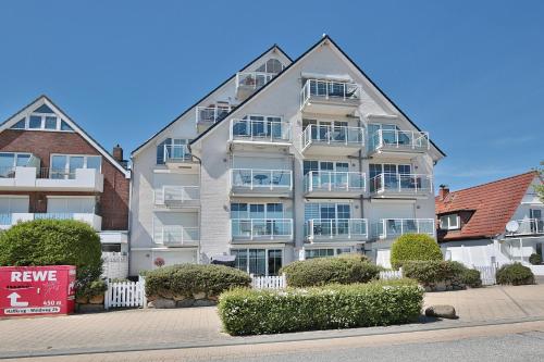 a large apartment building with bushes in front of it at Stranddomizil Stranddomizil Appartement 13 in Haffkrug