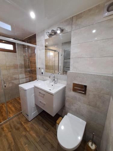 a bathroom with a toilet and a sink and a mirror at NADMORSKI RESORT in Niechorze