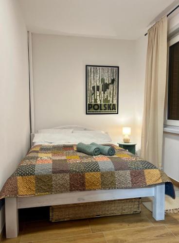 a bedroom with a bed with a quilt on it at Apartament Rosalia in Srebrna Góra