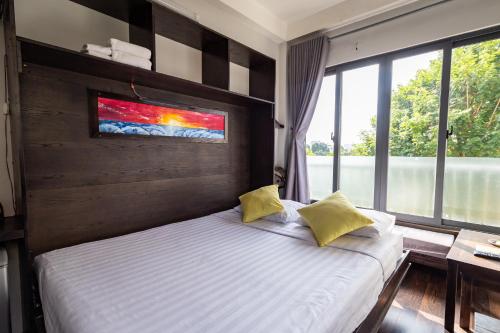 une chambre avec un lit et une grande fenêtre dans l'établissement Cozy Riverview of Livinginn, à Hô-Chi-Minh-Ville