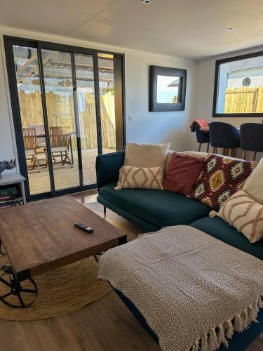 a living room with a couch and a table at Ty Baradoz, Maison vue mer et plage à pied in Névez