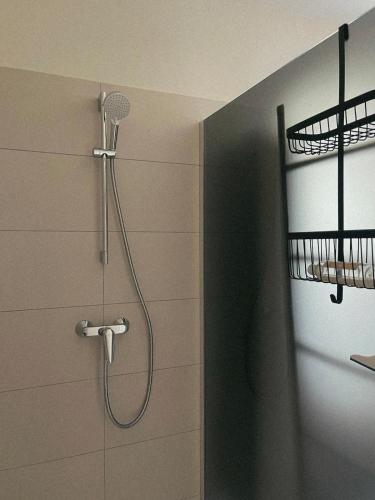 une douche avec pommeau de douche dans une salle de bain dans l'établissement Appartement spacieux 6 personnes sur le vieux port, à Porto-Vecchio