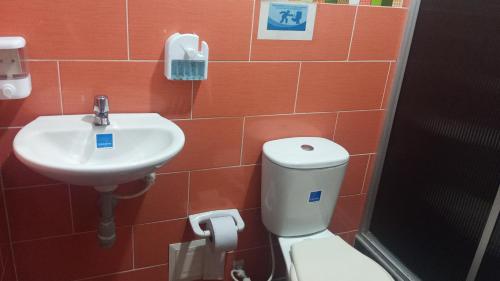a bathroom with a toilet and a sink at Hotel Casa Jairo in Neiva