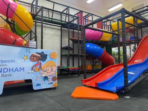 a playground with a sign next to a slide at Wyndham Rio Barra in Rio de Janeiro