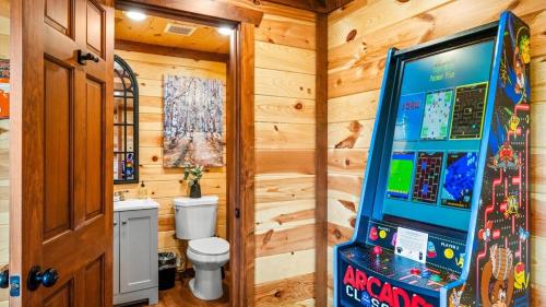 Un baño con una máquina de videojuegos en una habitación. en Luxe Memory Maker View Indoor Pool Games Sleeps 20, en Sevierville
