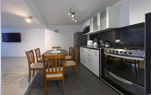 eine Küche mit Tisch und Stühlen und einem Herd in der Unterkunft Cajamarca Verde y bonita BI in Cajamarca