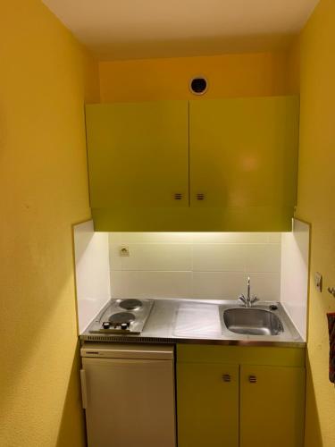 une petite cuisine avec un évier et une cuisinière dans l'établissement Appartement Bandol dans résidence privée avec piscine, à Bandol