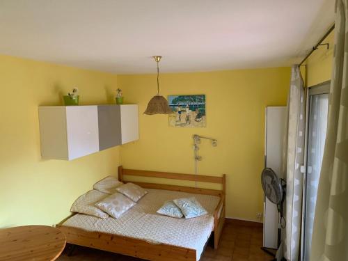 une petite chambre avec un lit et une table dans l'établissement Appartement Bandol dans résidence privée avec piscine, à Bandol