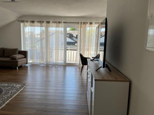 a living room with a flat screen tv on a dresser at Mevan Ferienwohnung in Gaienhofen