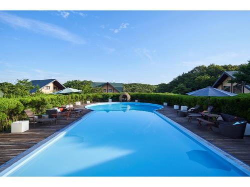a swimming pool on a deck with chairs and umbrellas at Fiore Shima - Vacation STAY 25660v in Shima