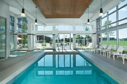 una piscina coperta con sedie, tavoli e finestre di Element Vaughan Southwest a Vaughan