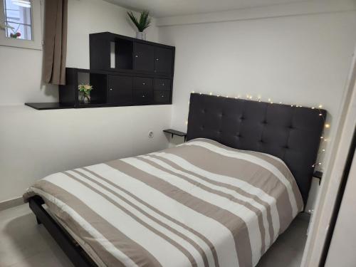 une chambre avec un lit avec une tête de lit noire dans l'établissement Bas de Villa, à Marseille