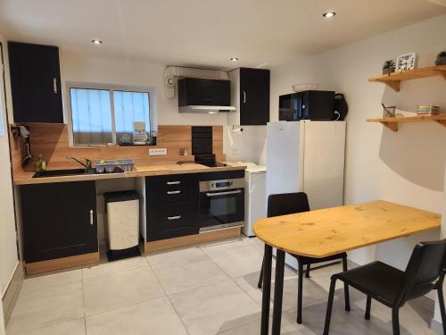 une cuisine avec des armoires noires et une table avec des chaises dans l'établissement Bas de Villa, à Marseille