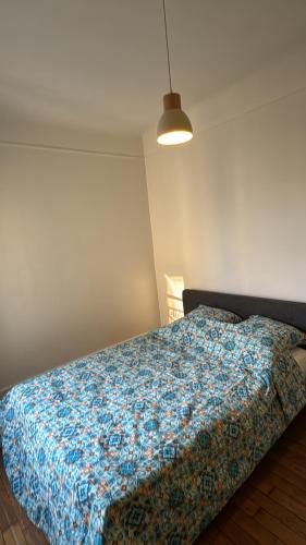 une chambre avec un lit avec une couverture bleue dans l'établissement Appartement proche Roland Garros, à Boulogne-Billancourt