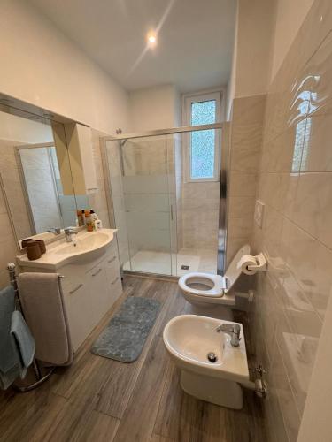 Un baño con lavabo, inodoro y ducha. en Casa Fiordaliso, en Lecco
