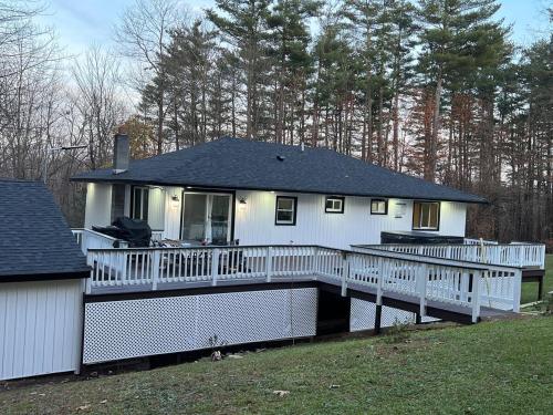 a large white house with a porch and a deck at Modern getaway in Catskills in Cairo