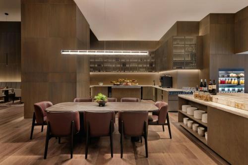 a kitchen and dining room with a table and chairs at JW Marriott Auckland in Auckland