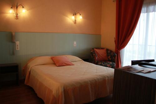 a hotel room with a bed and a chair at Hôtel Restaurant le Panorama in Évian-les-Bains