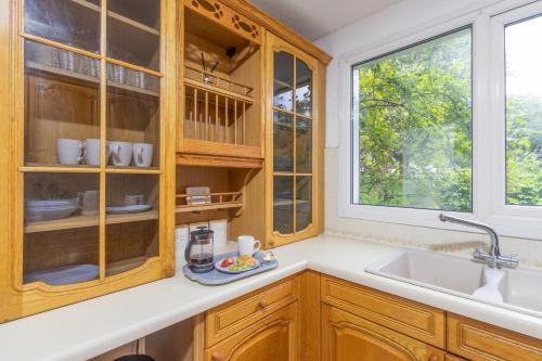 a kitchen with wooden cabinets and a sink and a window at Newly refurbed, 5BR, Sleeps 12 in Northampton