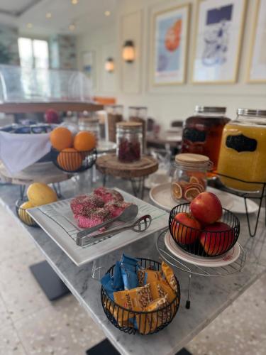 a table with plates of food and fruit on it at The Beach House in Birżebbuġa