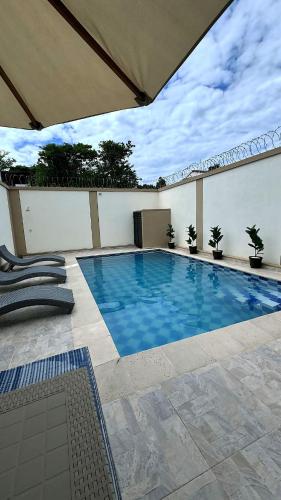 a swimming pool in a patio with an umbrella at Extraordinaria Casa Quinta privada - Ricaurte Cundinamarca in Ricaurte