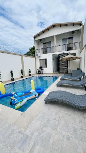 a swimming pool with chairs and a house at Extraordinaria Casa Quinta privada - Ricaurte Cundinamarca in Ricaurte