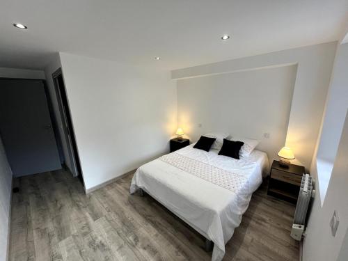 - une chambre blanche avec un lit et deux lampes dans l'établissement Cosy Appartement - Verrens-Arvey, à Verrens-Arvey