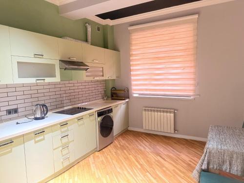a kitchen with white cabinets and a window at Luxury City Baku Apart Hotel in Baku
