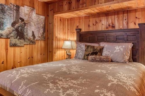 a bedroom with a bed in a wooden wall at Honey Bear Slopes by Avada Properties in Gatlinburg
