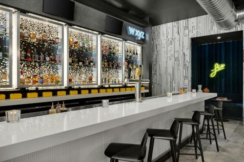 a bar with a row of bar stools at Aloft Indianapolis Downtown in Indianapolis