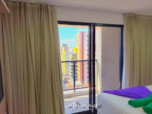 a bedroom with a window with a view of a city at Move - Tambaú in Tambaú