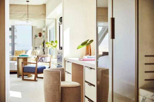 a room with a desk and chairs and a living room at Hotel Arts Barcelona in Barcelona