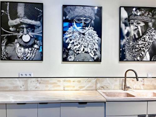 a kitchen with three pictures of men on the wall at The Palm Tree House Alentejo Private swimming pool 6 suites Iconic Palm tree in Alvito