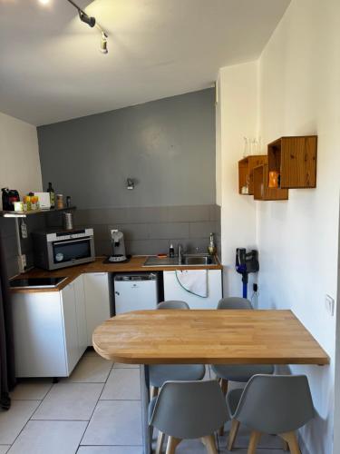 une cuisine avec une table et des chaises en bois dans l'établissement City Studio, à Cavalaire-sur-Mer