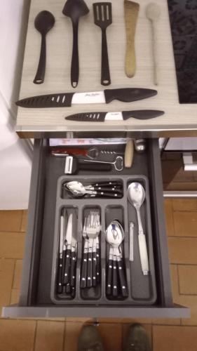 un tiroir rempli d'ustensiles de cuisine sur un comptoir dans l'établissement Appartement city center forcalquier, à Forcalquier