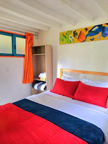 a bedroom with a large bed with red pillows at Hotel Marrokos Aeropuerto José María Córdova in Rionegro